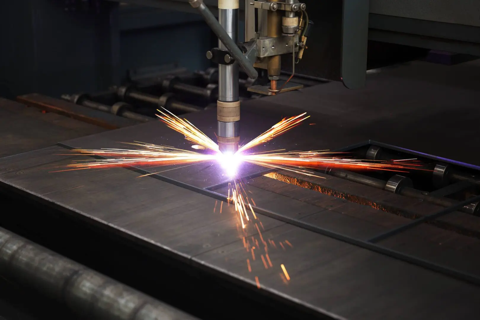 Close up of a metal cutting plasma torch emitting bright sparks