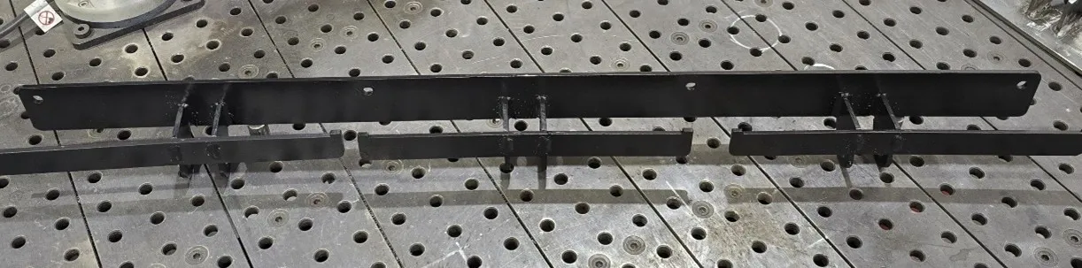 Black welded support rail on perforated table