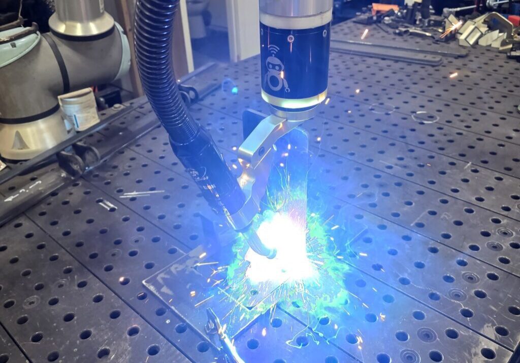 Industrial robot welding metal with bright sparks